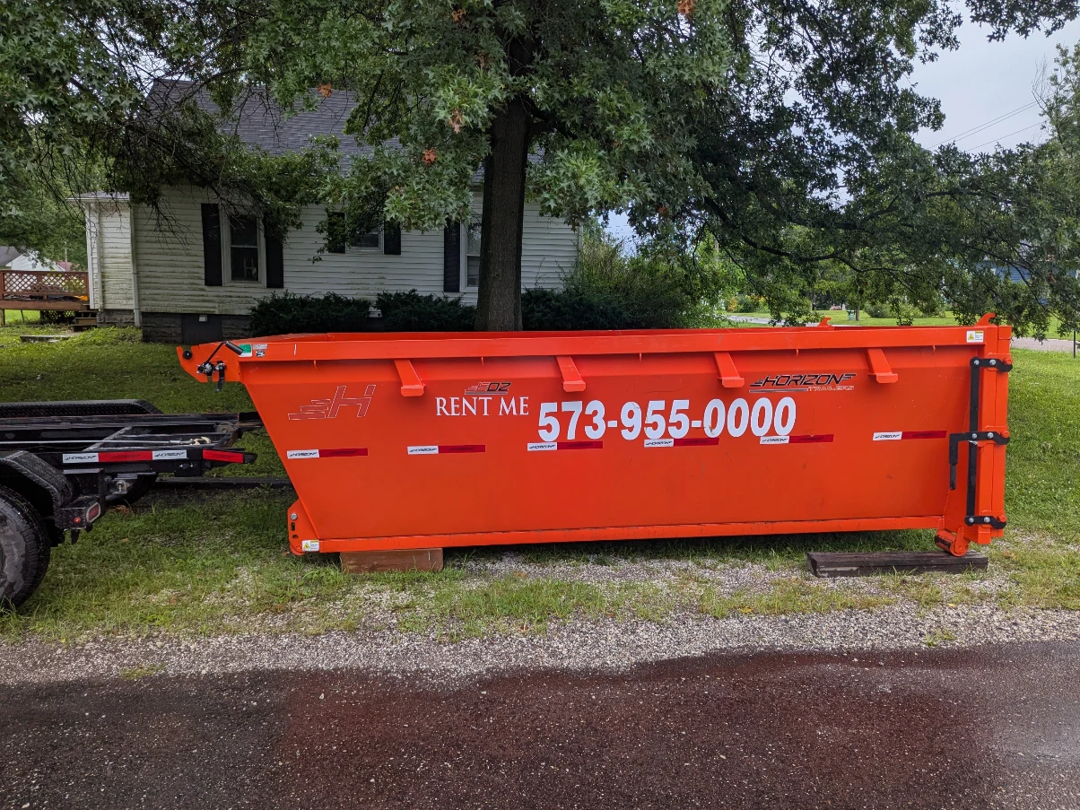 Orange Me Gusta rental dumpster with Rent Me and phone number 573-955-0000 on its side